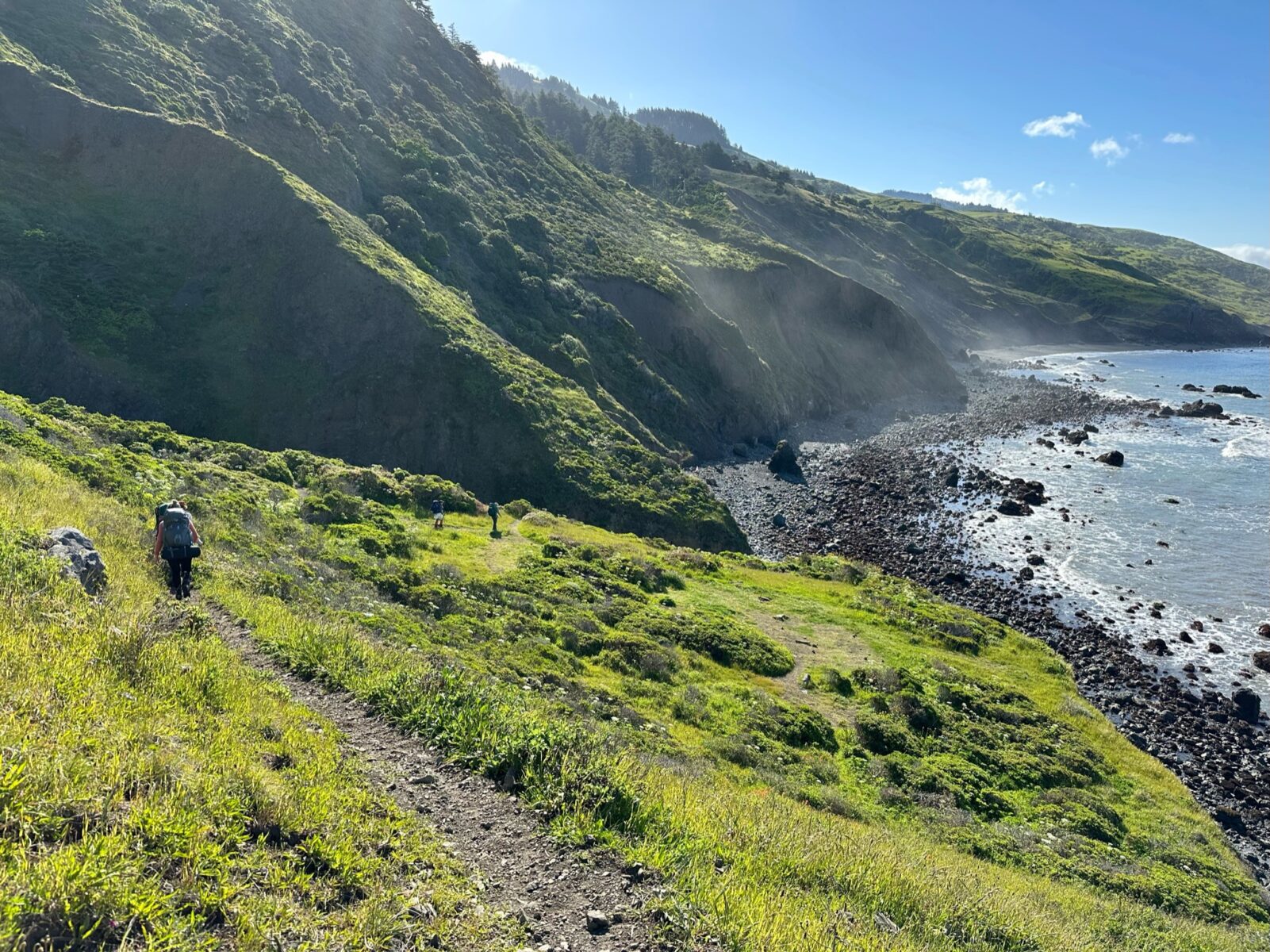 Hikers trekking through the cliffsides of the lost coast