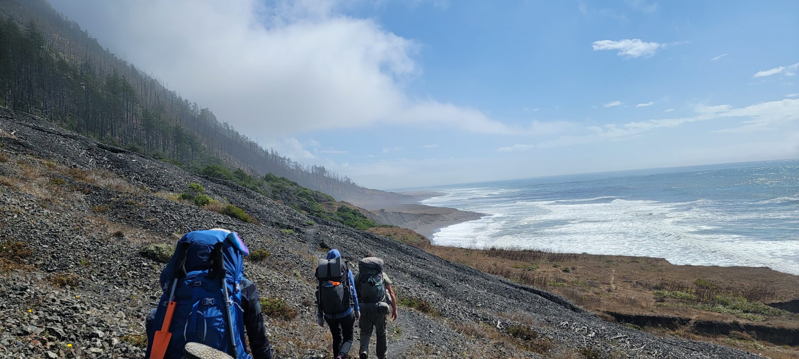 Backpackers walking along the coastline of the LCT